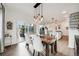 Bright dining room features modern lighting, wood floors, and sliding glass doors to outdoor patio at 14384 Big Stone Dr, Parker, CO 80134