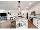 Open kitchen boasts a large island with a sink, stainless steel appliances, and stylish pendant lighting at 14384 Big Stone Dr, Parker, CO 80134