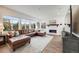 Spacious living room featuring a brown leather couch, fireplace, and large windows for ample natural light at 14384 Big Stone Dr, Parker, CO 80134