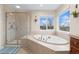 Bright bathroom features a soaking tub under a window and a glass-enclosed shower at 5289 W Euclid Pl, Littleton, CO 80123
