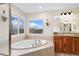 The bathroom boasts a soaking tub under a window, a sink, and a vanity at 5289 W Euclid Pl, Littleton, CO 80123