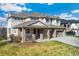 Beautiful two-story home boasting a three-car garage, front porch, and well-maintained lawn with brick accents at 5289 W Euclid Pl, Littleton, CO 80123