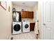 Functional laundry room with washer, dryer, storage cabinets, and tile flooring at 5289 W Euclid Pl, Littleton, CO 80123