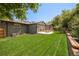 Large backyard with an expansive lawn, patio seating, and mature trees for privacy at 621 S Harrison Ln, Denver, CO 80209
