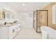 Bright bathroom with double sinks, vanity, and a shower featuring black fixtures at 621 S Harrison Ln, Denver, CO 80209