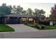 Charming single-story home with dark exterior, lush landscaping, and a two-car garage at 621 S Harrison Ln, Denver, CO 80209
