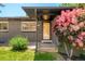 Close-up of a home's entrance, highlighting a small porch, door, and colorful mature flowering bushes at 621 S Harrison Ln, Denver, CO 80209