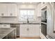 Modern kitchen with white cabinetry, stainless steel appliances, and marble countertops at 621 S Harrison Ln, Denver, CO 80209