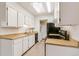 Bright kitchen with white cabinets, wood countertops, stainless sink, and modern appliances at 1820 Newland Ct # 313, Lakewood, CO 80214