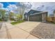 Blue home featuring a driveway, stone accents, a two-car garage, and manicured landscaping at 12133 Crabapple St, Broomfield, CO 80020