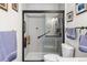 Modern bathroom with a glass-enclosed shower, grab bar, and white tile at 3857 Mossy Rock Dr # 201, Highlands Ranch, CO 80126
