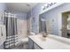 Well-lit bathroom with a shower/tub combo, blue walls, and a neutral color palette at 3857 Mossy Rock Dr # 201, Highlands Ranch, CO 80126