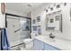 Bathroom featuring a glass-enclosed shower, blue vanity, and modern lighting at 3857 Mossy Rock Dr # 201, Highlands Ranch, CO 80126