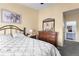 Cozy bedroom with dark wood furniture, neutral wall color, and adjacent bathroom access at 3857 Mossy Rock Dr # 201, Highlands Ranch, CO 80126