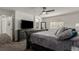 Primary bedroom with large bed, ceiling fan, window, and view into ensuite bath at 3788 Chavez St, Brighton, CO 80601