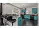 Bright kitchen with granite counters, stainless appliances, wood floors, and unique turquoise colored cabinets at 3788 Chavez St, Brighton, CO 80601