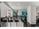 Modern kitchen with a breakfast bar, stylish bar stools, and vibrant blue cabinets at 3788 Chavez St, Brighton, CO 80601
