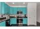 Kitchen features black stainless steel appliances, subway tile backsplash, granite counters, and turquoise cabinets at 3788 Chavez St, Brighton, CO 80601