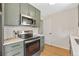 Bright kitchen with stainless steel appliances, white subway tile backsplash, and green cabinets at 1205 W 101St Ave, Northglenn, CO 80260