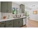 Modern kitchen featuring sleek white countertops, green cabinets, stainless steel appliances, and a bright window at 1205 W 101St Ave, Northglenn, CO 80260