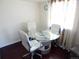 Bright dining area featuring a glass table, white chairs, and hardwood floors at 1255 S Wheeling Way, Aurora, CO 80012