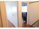Hallway showing two open doorways, white walls, light fixture, and wood floors at 1255 S Wheeling Way, Aurora, CO 80012