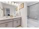 Modern bathroom featuring double sinks, vanity with gray cabinets and a bathtub with shower at 8049 Monte Vista Cir, Littleton, CO 80125