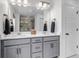 Bathroom featuring a grey vanity with dual sinks, a bright white countertop, and tile flooring at 8049 Monte Vista Cir, Littleton, CO 80125