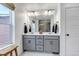 Bathroom featuring double sinks with a grey vanity and modern fixtures, plus a large mirror at 8049 Monte Vista Cir, Littleton, CO 80125