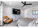 Bright bedroom with a ceiling fan, dresser, side chair, and large windows at 8049 Monte Vista Cir, Littleton, CO 80125