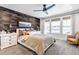 Primary bedroom with a decorative wood accent wall, fan, and neutral color palette at 8049 Monte Vista Cir, Littleton, CO 80125