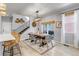 Dining area with a wooden table, woven chairs, and a large window offering natural light at 8049 Monte Vista Cir, Littleton, CO 80125