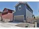 Charming two-story blue home featuring a gray garage door and well-maintained landscaping on a sunny day at 8049 Monte Vista Cir, Littleton, CO 80125