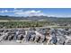 Expansive aerial view of a vibrant residential community nestled against a stunning mountain range and blue sky at 8049 Monte Vista Cir, Littleton, CO 80125