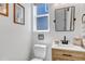 Stylish powder room with modern fixtures, a wood vanity, and tasteful decor at 8049 Monte Vista Cir, Littleton, CO 80125