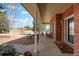 Covered front porch with brick facade, offering a cozy seating area and views of the landscaped yard at 2174 Meadow Vale Rd, Longmont, CO 80504