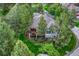 Aerial view of the house nestled among mature trees, with a spacious deck and landscaped yard at 3201 Country Club Pkwy, Castle Rock, CO 80108