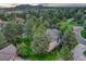 An aerial view reveals a property surrounded by lush trees and manicured landscaping, in a serene neighborhood at 3201 Country Club Pkwy, Castle Rock, CO 80108