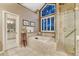 The bright bathroom features a soaking tub, glass shower, and a large window at 3201 Country Club Pkwy, Castle Rock, CO 80108