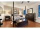 Beautifully decorated bedroom with hardwood floors, four-poster bed, dresser, and ample natural light at 3201 Country Club Pkwy, Castle Rock, CO 80108