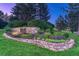 Stone entrance to 'The Greens' community is beautifully landscaped with colorful flowers at 3201 Country Club Pkwy, Castle Rock, CO 80108