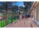 Deck with stone pillars, black railing, wicker seating, and a view of lush green surroundings at 3201 Country Club Pkwy, Castle Rock, CO 80108