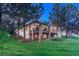 Rear exterior shows a two-story house with a stone pillar patio and a well-maintained lawn at 3201 Country Club Pkwy, Castle Rock, CO 80108