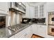 A well-equipped kitchen featuring stainless steel appliances, black backsplash, granite countertops, and white cabinets at 3201 Country Club Pkwy, Castle Rock, CO 80108