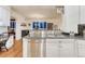 Open kitchen featuring granite counters, stainless dishwasher, and hardwood floors overlooking the dining and living areas at 3201 Country Club Pkwy, Castle Rock, CO 80108
