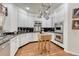 Well lit kitchen with stainless steel appliances, white cabinets, black backsplash, and hardwood floors at 3201 Country Club Pkwy, Castle Rock, CO 80108