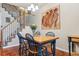 Cozy dining area with hardwood floors is complemented by a charming staircase and artistic wall decor at 6237 Trailhead Rd, Highlands Ranch, CO 80130