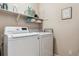 Well-equipped laundry room features modern washer and dryer units and ample shelving for storage and organization at 6237 Trailhead Rd, Highlands Ranch, CO 80130