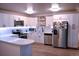 Bright kitchen with white cabinets, stainless steel appliances, and open layout to the dining area at 650 S Clinton St # 2A, Denver, CO 80247