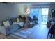 A well-lit living room features a comfortable couch, chair, and a sliding door to a balcony at 650 S Clinton St # 2A, Denver, CO 80247